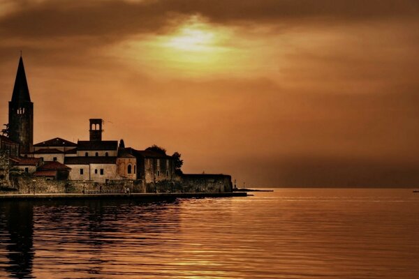 Turm am Ufer im Hintergrund des Sonnenuntergangs