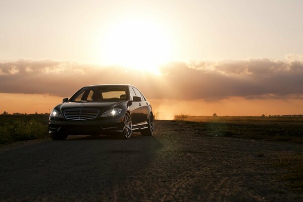 Rigorosa Mercedes sullo sfondo di nuvole e sole al tramonto nel campo