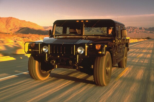 Hummer SUV noir sur la route dans le désert