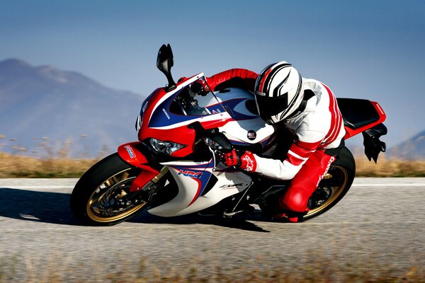 Hombre en motocicleta roja gira