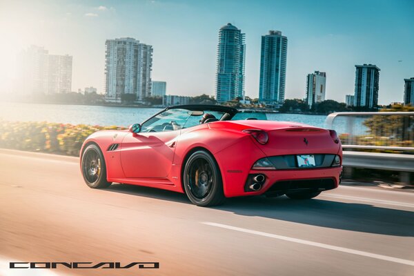 Red Ferrari Convertible car rides on the road