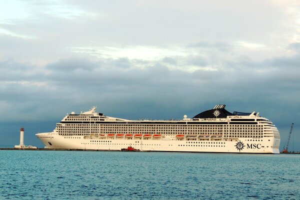 Kreuzfahrtschiff im Wasser vor dem Hintergrund eines Leuchtturms