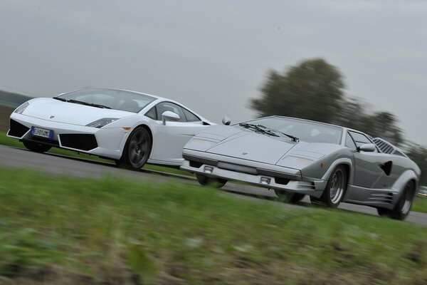 Two lamborghini countach and gallardo cars on the highway