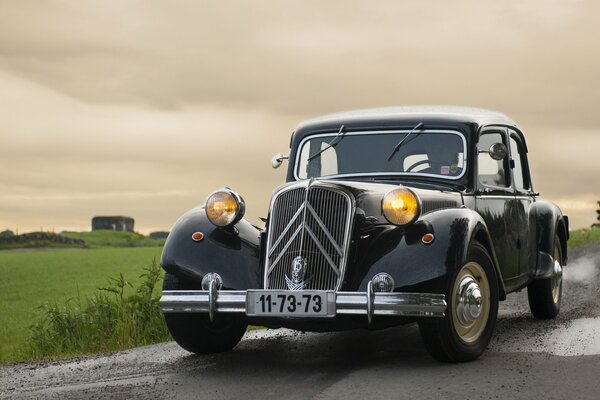 Citroën negro en la carretera mojada