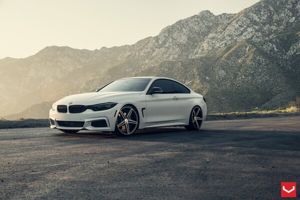 L auto bianca del marchio bmw sullo sfondo delle montagne e dell alba