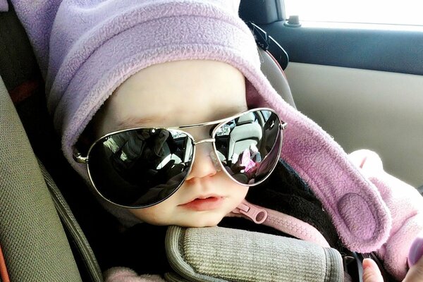 A small child in a car with glasses