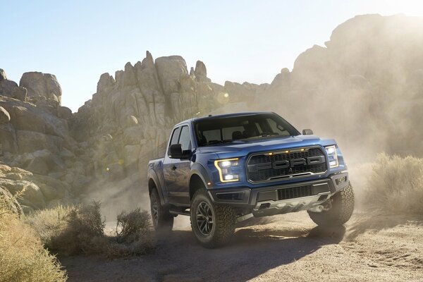 Ford drives through the sand spreading dust