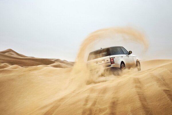 White SUV in a skid on the sand