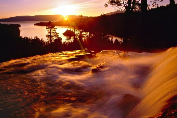 Брызги водопада отражают лучи солнца