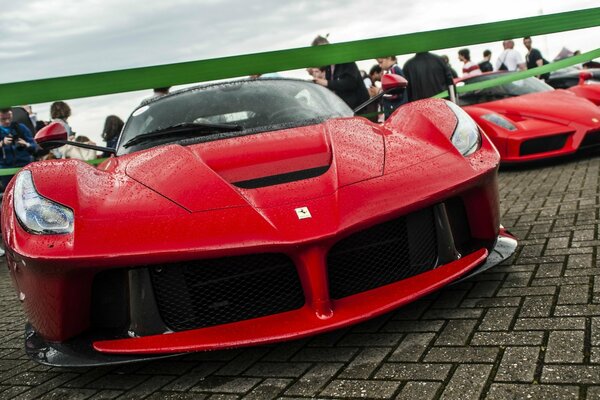 Red Ferrari supercar on display in the rain