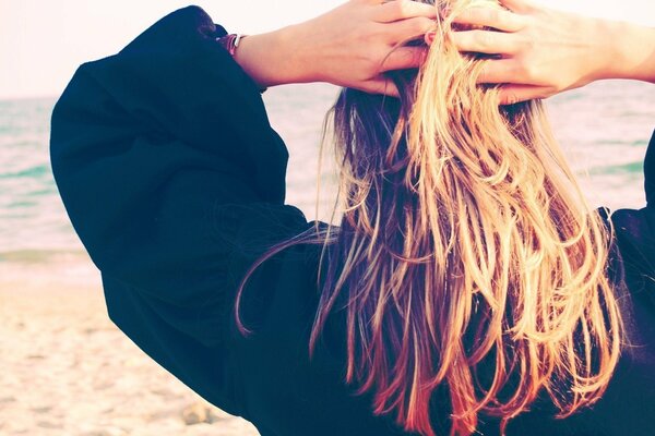 Blondine am Sandstrand von hinten