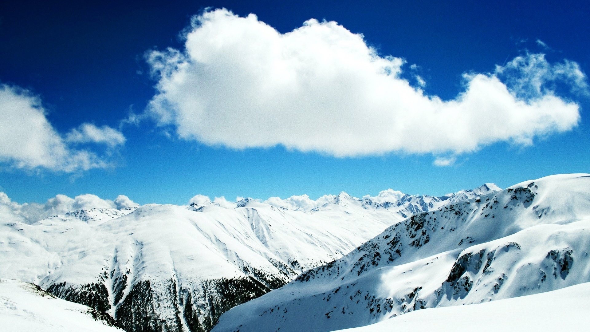 haut dans les montagnes tapis de neige nuages montagnes ciel hiver nature paysage altitude congères sommets gel bleu