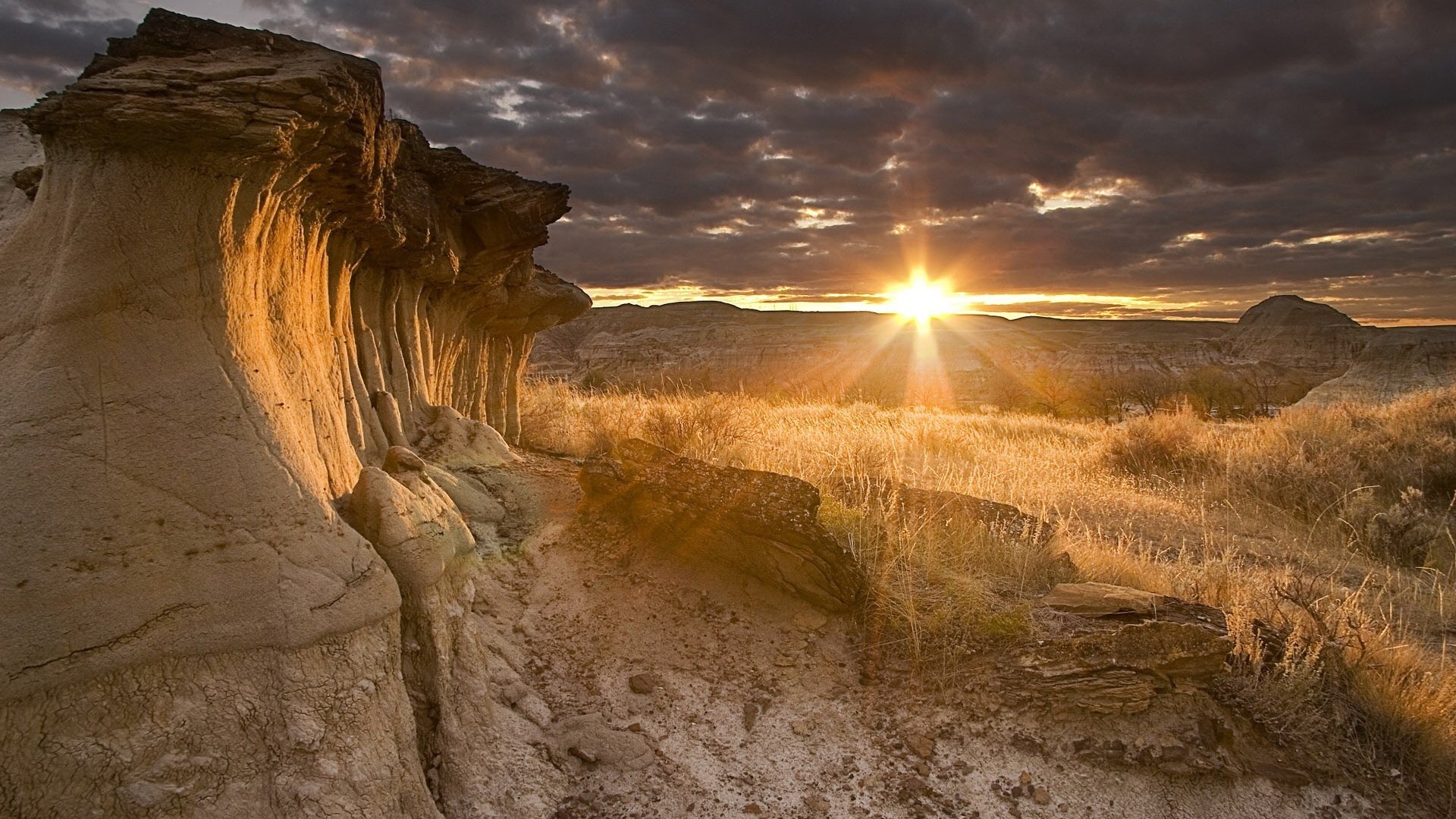 estrella llamada sol rocas arenosas de las montañas hierba seca puesta de sol paisaje nubes