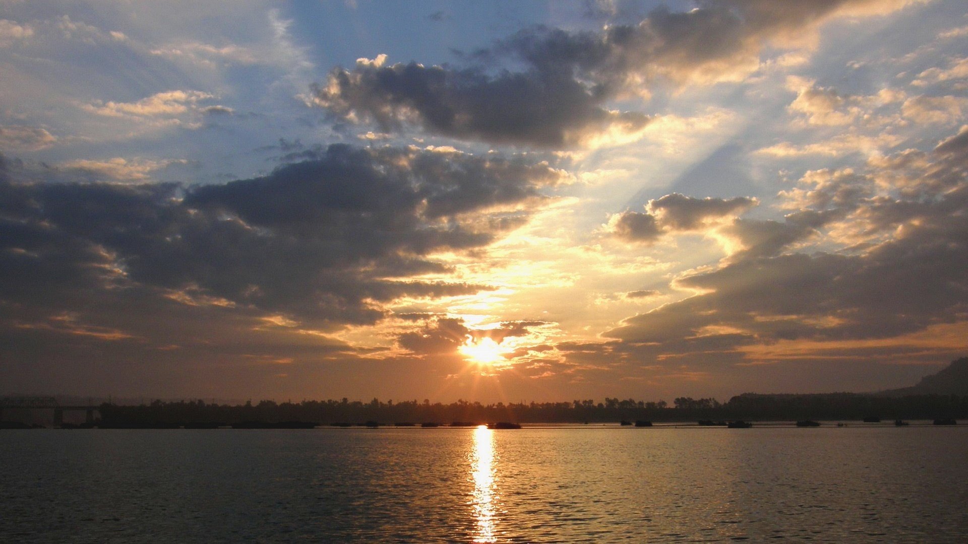 soleil se lève nuages gris forêt loin reflet de l eau eau ciel soleil nuages chemin sur l eau paysage