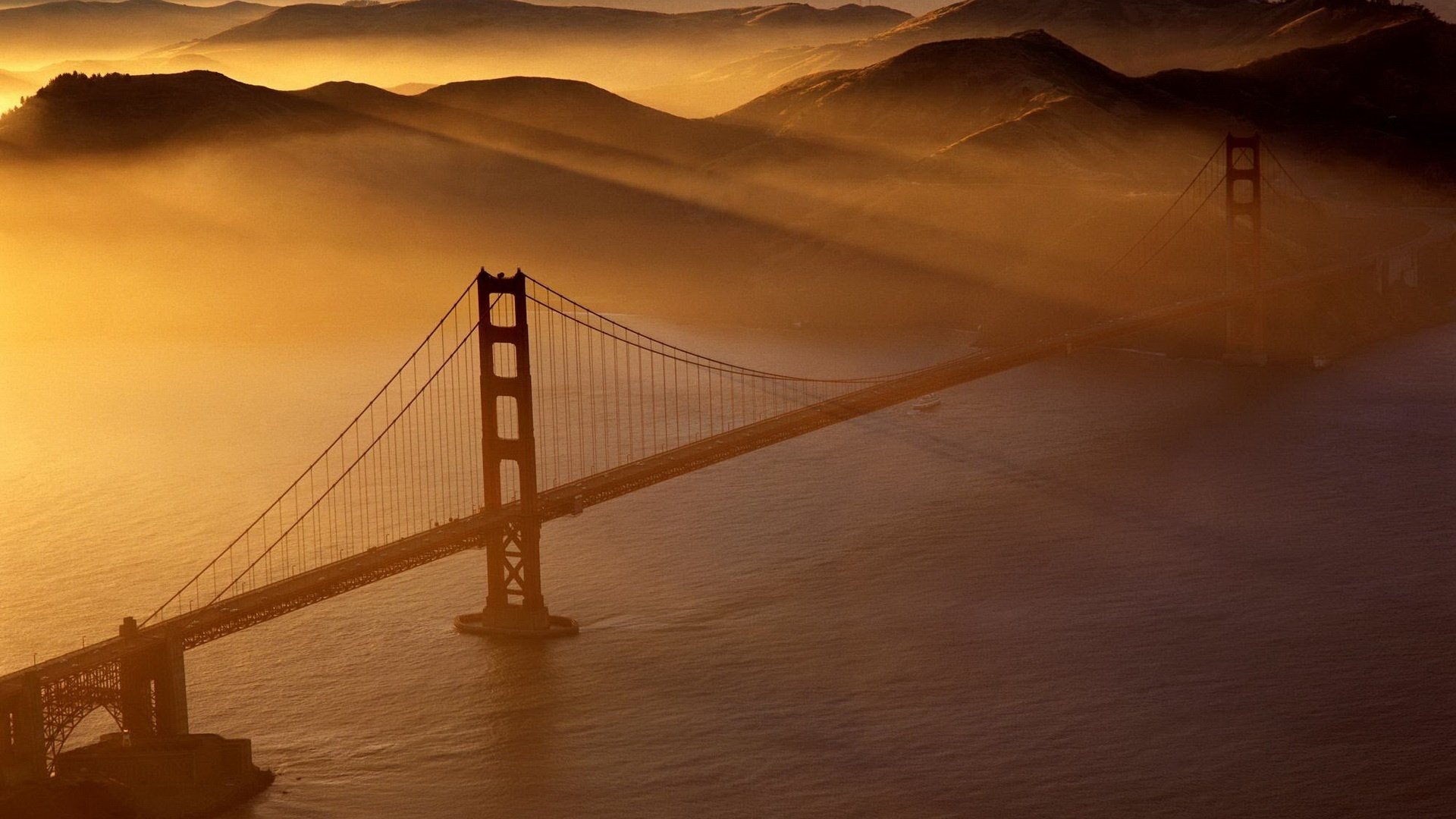 iron bridge fog the ocean water mountains the rays of the sun bridge