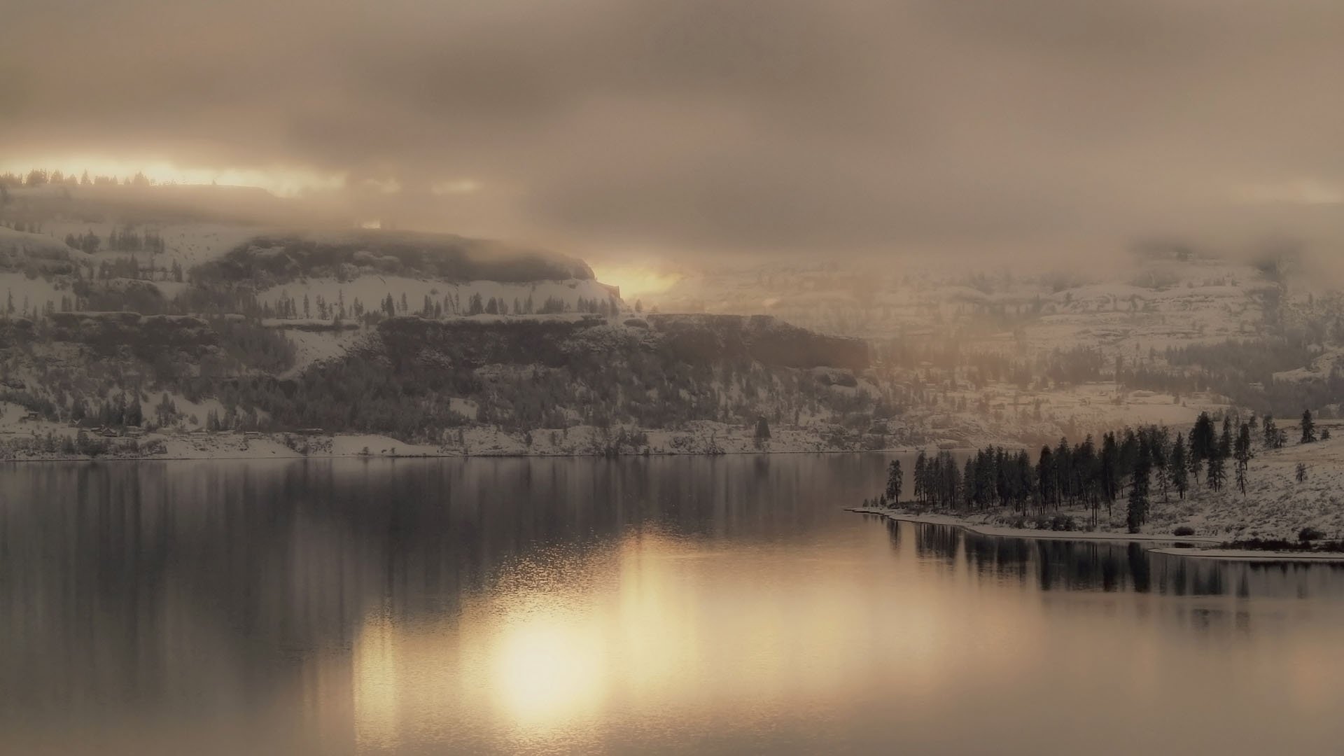 lago ai piedi inverno montagne acqua neve superficie liscia grigio nuvole foschia alberi di natale foresta paesaggio vista natura