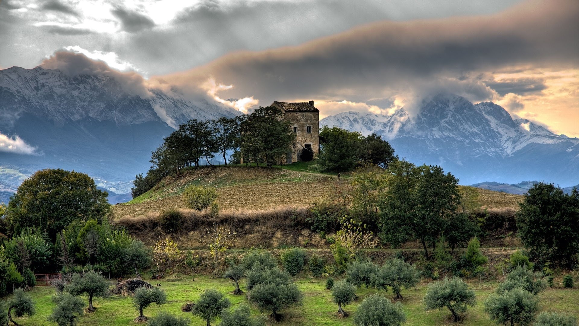 tone building hillock thunderstorm houses house clouds clouds bushes trees mountains valley hill greenery nature landscape vegetation