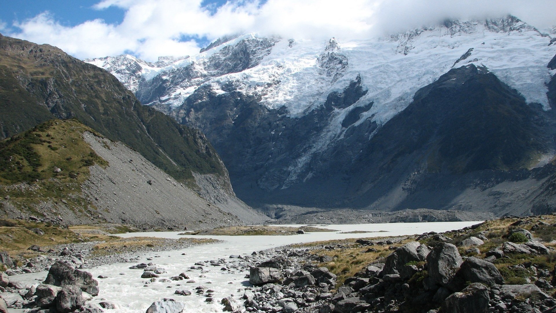 distant lands wildlife stream mountains rocks stones clouds landscape