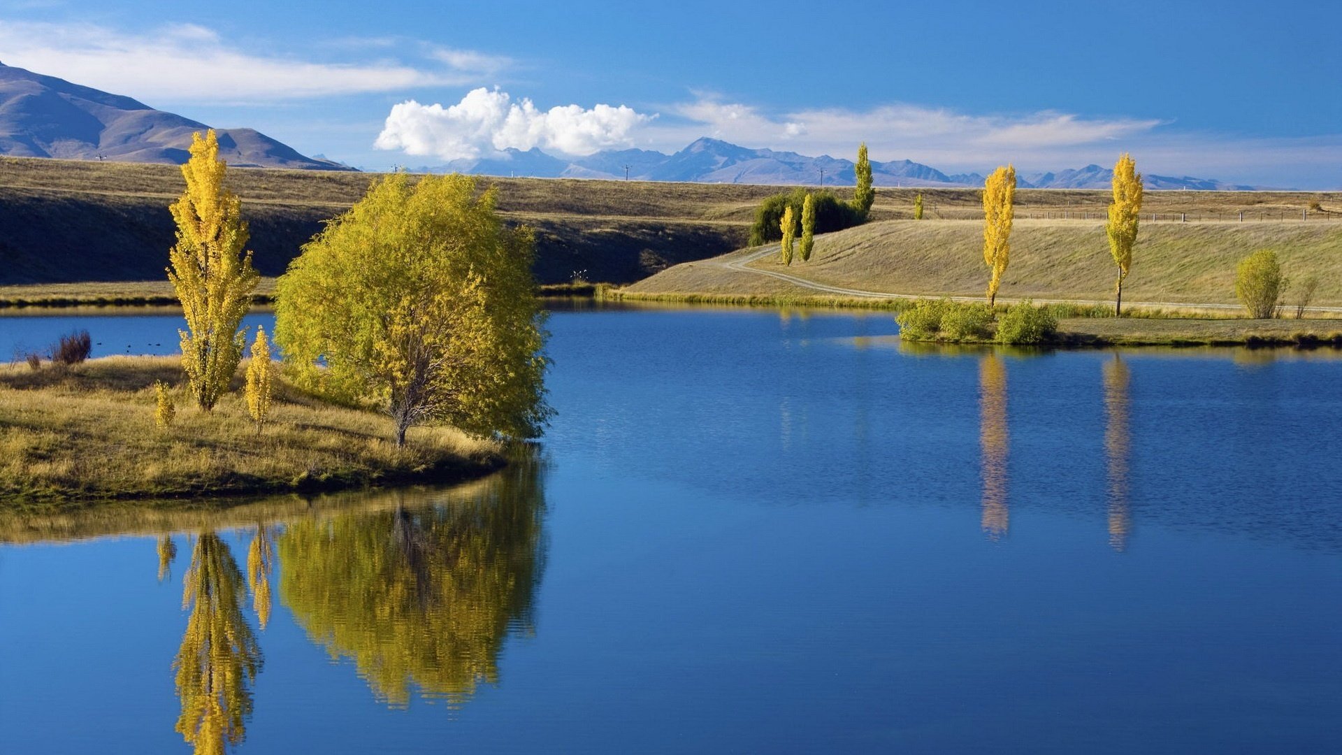 insel herbstliche zeit blaues wasser wasser himmel see wolken reflexion bäume hügel natur landschaft frühherbst