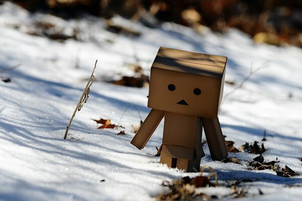 Cute cardboard man in winter. Melting snow