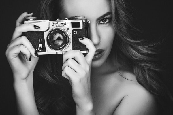 Black and white photo of a girl with a camera in her hands