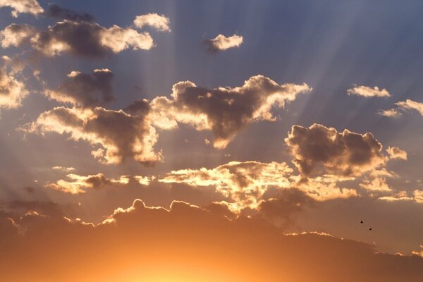 La luce del sole si fa strada tra le nuvole al tramonto