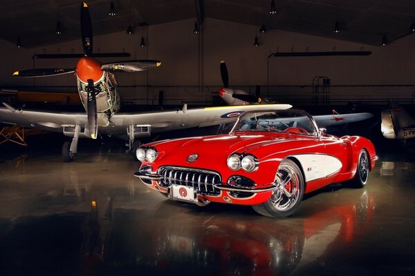 Rotes schönes Auto und Flugzeug im Hangar