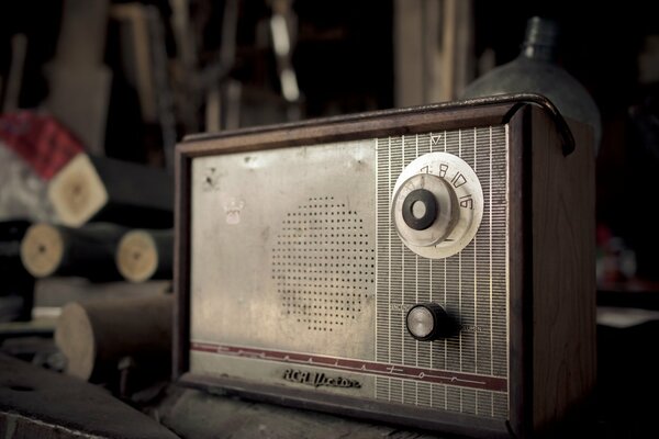 Alte Radioempfänger auf dem Hintergrund von Werkzeugen und Teilen