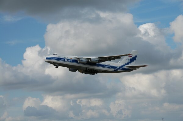 Militär-Transportflugzeug auf dem Hintergrund der weißen Wolken