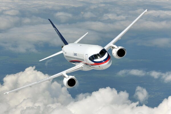 El avión SuperJet vuela sobre la superficie del cielo