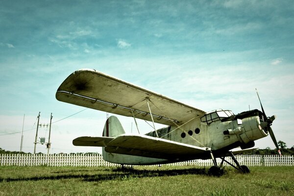 An old plane stands on a beautiful sky background