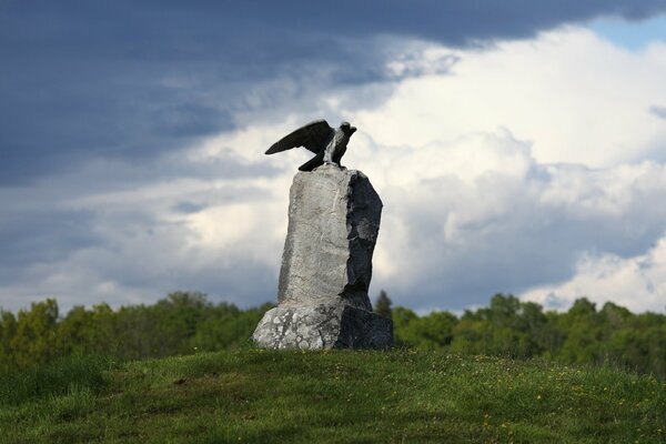 Stone statue of an eagle with greenery around