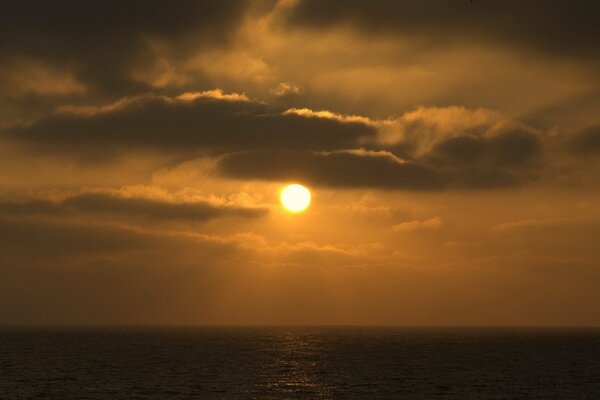 Puesta de sol naranja y nubes oscuras