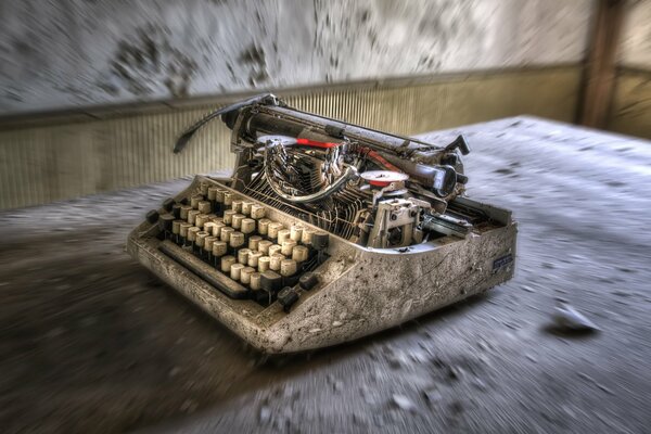 Alte Schreibmaschine auf schmutzigem Boden