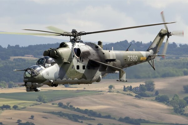 The Soviet Mi-24 transport and combat helicopter soars in the sky