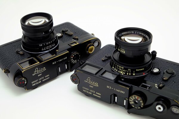 Black leica cameras on a white background