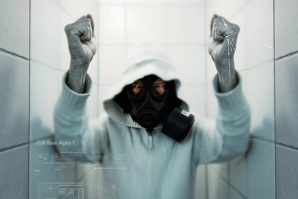 A man in a gas mask breaks glass with his hands