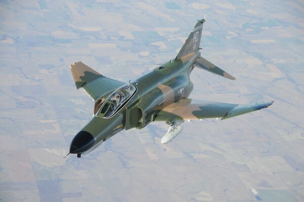 Photo of an f-4 flying over the ground