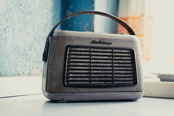 An old radio set against a blue wall