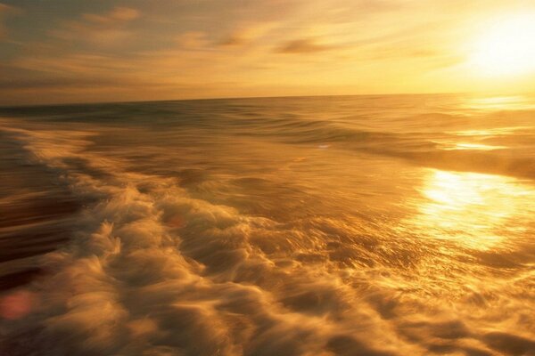 Tormenta de mar en medio de una puesta de sol dorada