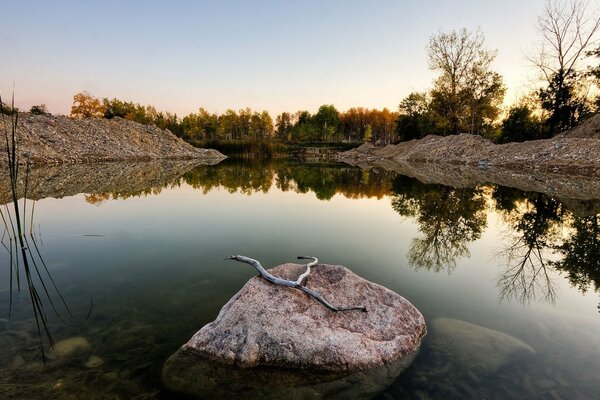 The stone is grayer than the pond in the evening