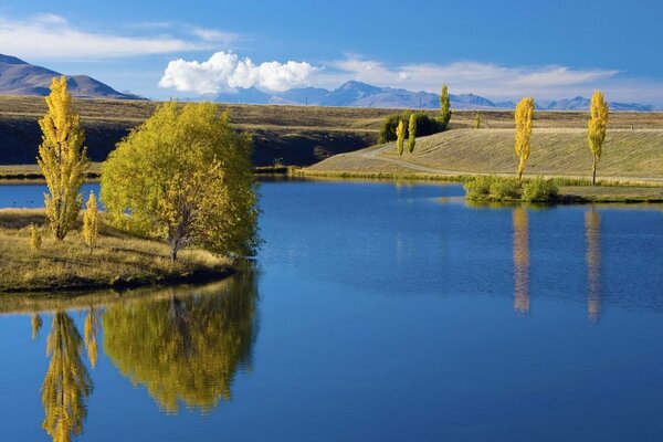 An island in a blue lake in early autumn