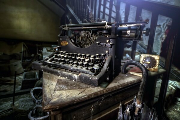 Vecchia macchina da scrivere rara con un orologio sullo sfondo di una scala