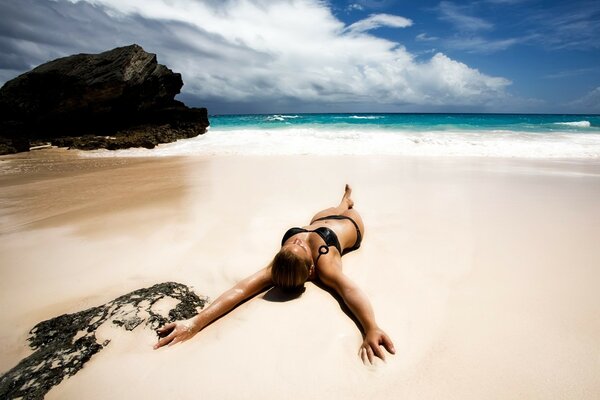 Sunbathing woman on white sand