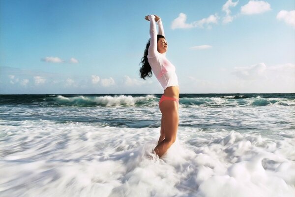 The girl enjoys the sea waves