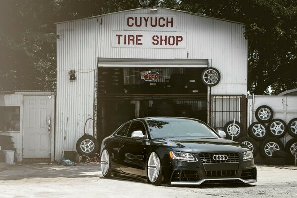 Beautiful black Audi car on the background of a service station