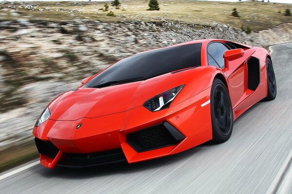 A red lamborghini is driving at high speed on the road