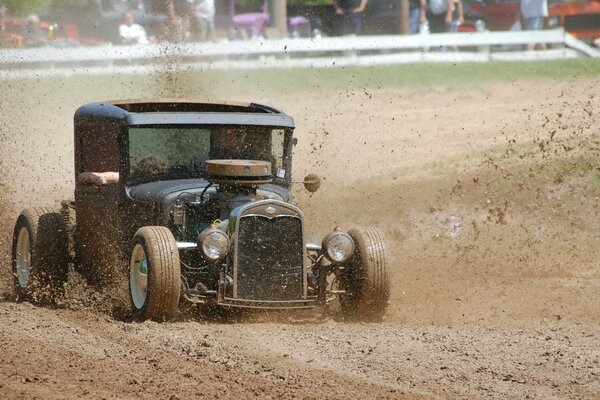 An old car submerged entirely in mud