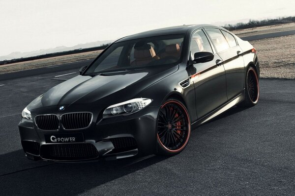 Black BMW with red wheels