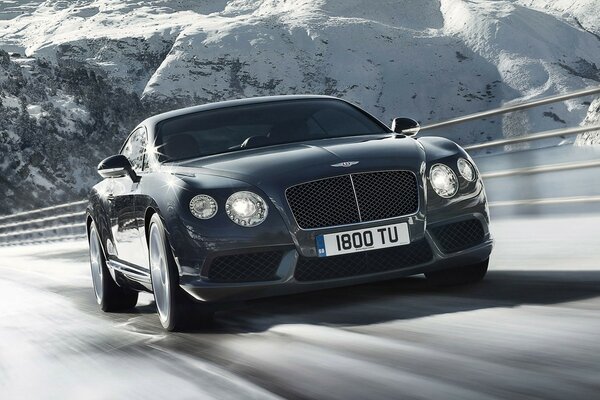 Bentley supersports sur la route sur fond de rochers enneigés